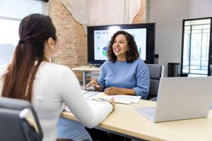 Two women in a meeting discussing benefits options and how to maximize benefits